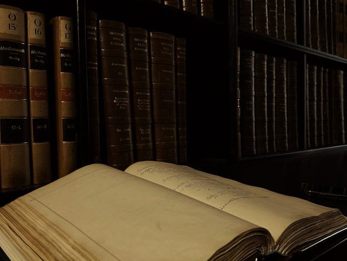 Libro abierto delante de una estantería con más libros de derecho laboral